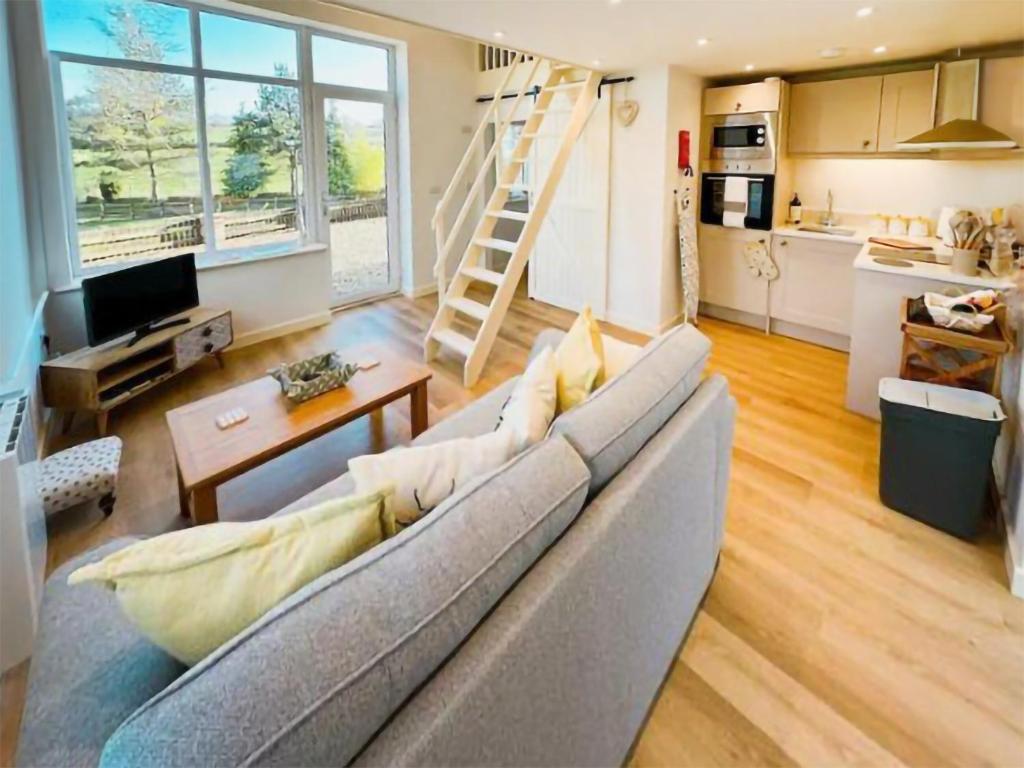 a living room with a couch and a kitchen at Honey Bee Cottage in Welshpool