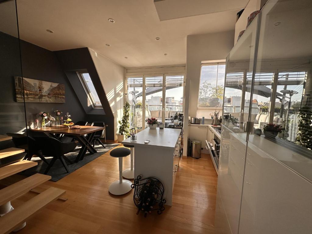 een keuken en eetkamer met een tafel en stoelen bij City-Penthouse mit 4 Terassen und Whirlpool in Wenen
