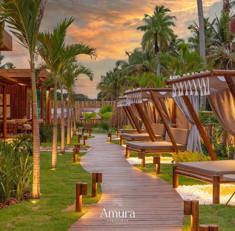 a wooden walkway with benches in a resort at APARTAMENTO AMURA in Tamandaré