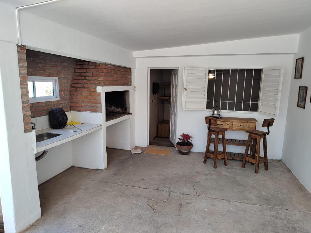 a kitchen with a table and a brick wall at La Mora Departamento in Mina Clavero