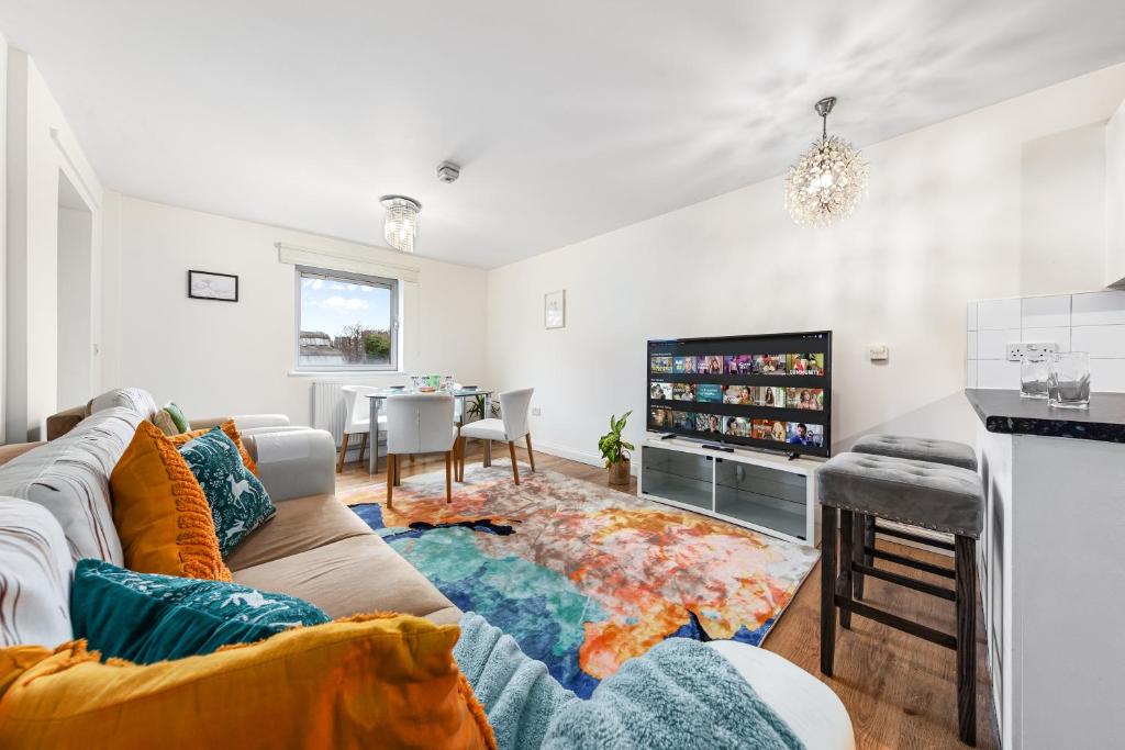 a living room with a couch and a tv at Modern Spacious 1 Bedroom Flat in Camden in London