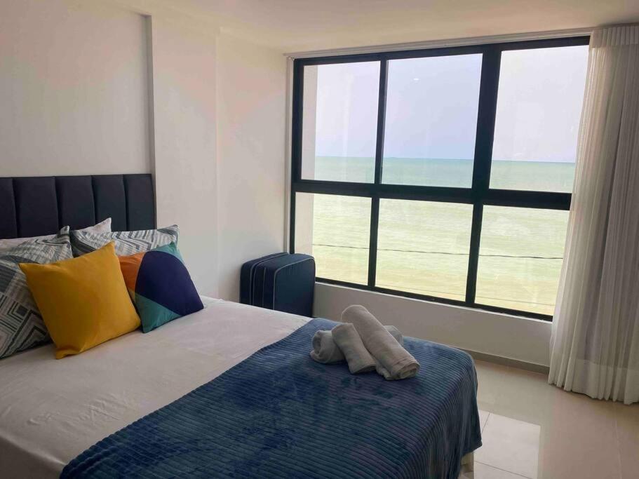 - une chambre avec un lit et une grande fenêtre dans l'établissement Pé na areia com vista mar 203, à João Pessoa