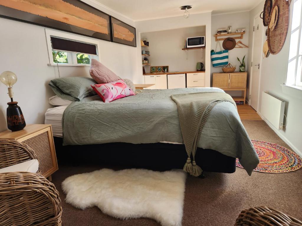 a bedroom with a large bed and a rug at 'Haumoana' in Olde Beach. in Waikanae