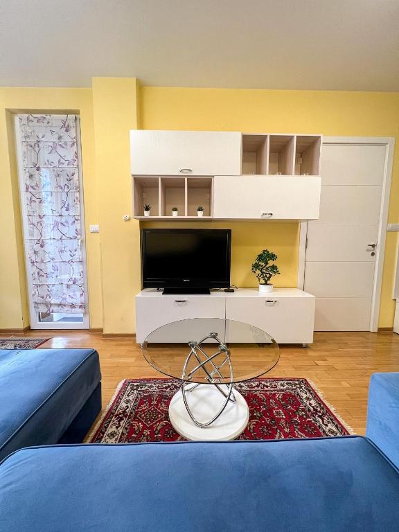 a living room with a tv and a blue couch at Mega Lux Apartment in Vračar (historical)