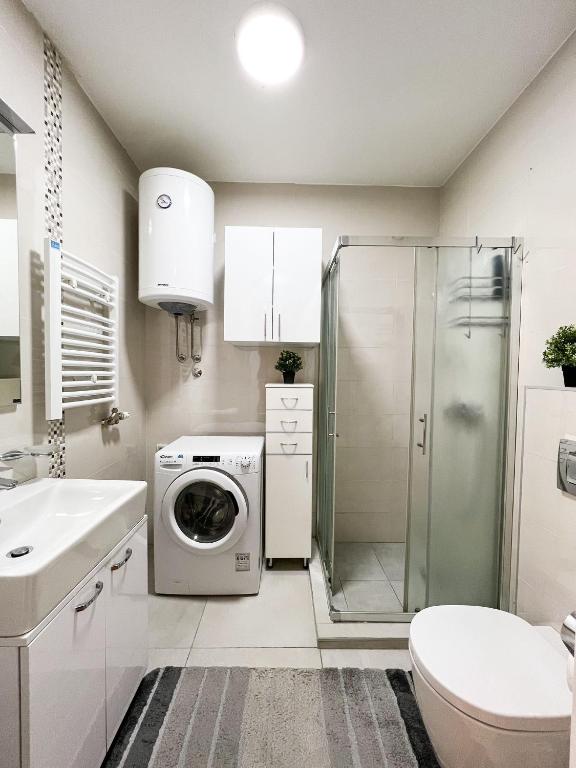 a white bathroom with a washing machine and a shower at Mega Lux Apartment in Vračar (historical)
