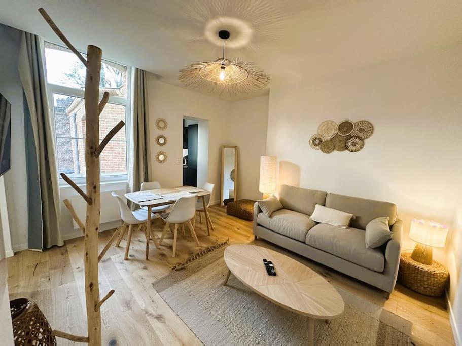 a living room with a couch and a table at L'Escapade des Privilégiés in Amiens