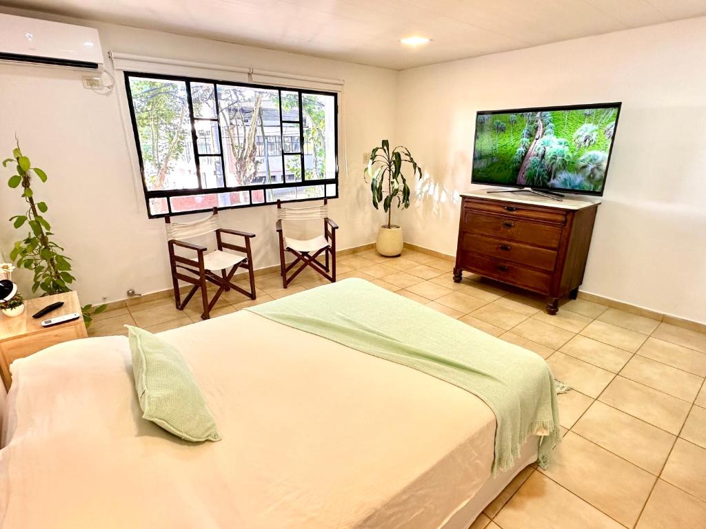 a bedroom with a bed and a flat screen tv at Ingá Puerto Colón l in Colón
