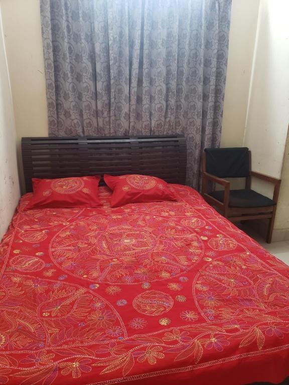 - un lit rouge avec des oreillers rouges dans une chambre dans l'établissement Private double room with attached bathroom nikunja 2, à Dhaka