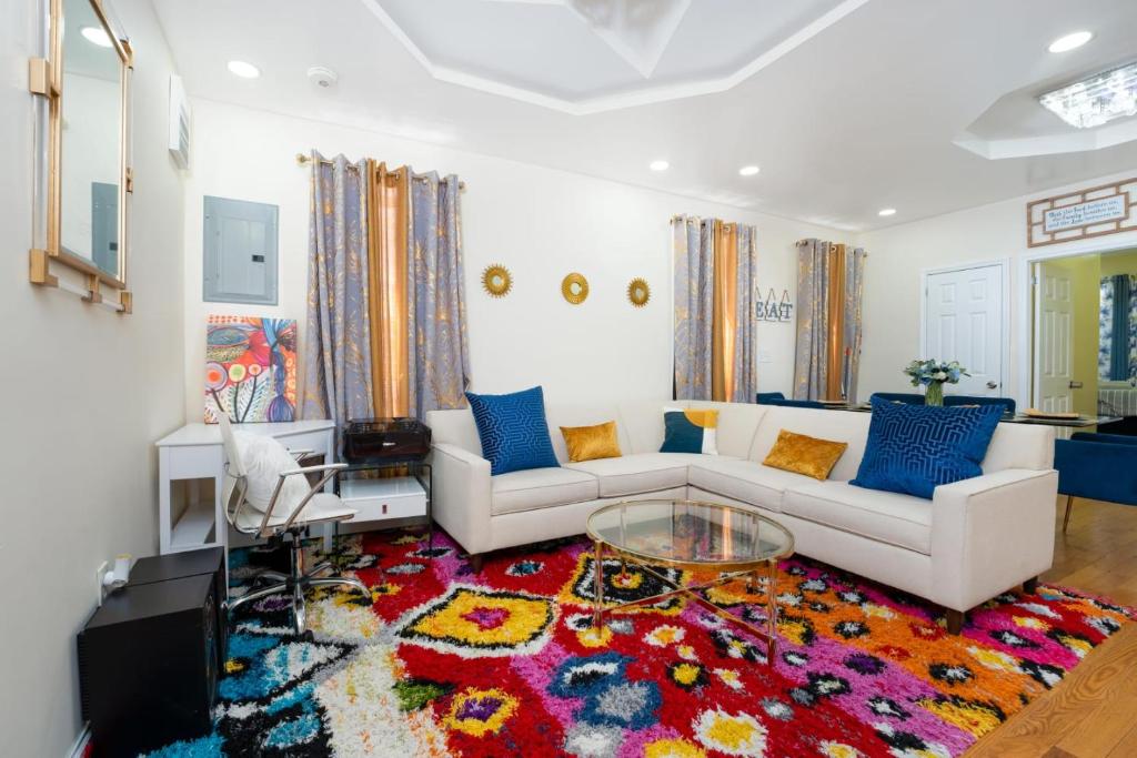 a living room with a white couch and a colorful rug at A Slice of Paradise vacation rental in Brooklyn