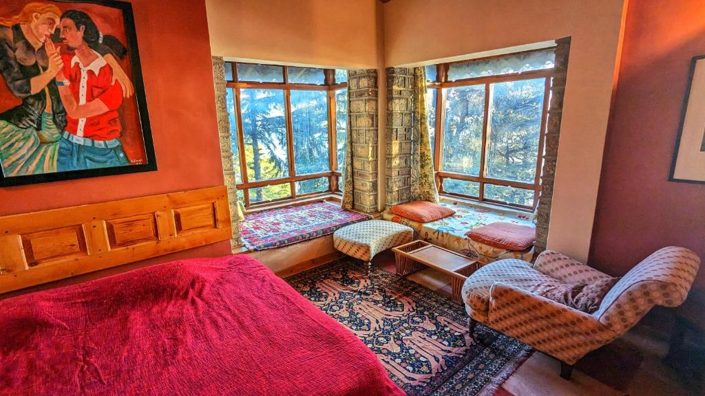 a bedroom with a bed and chairs and windows at Mountain View 3bhk Near Mall Road Deodar Retreat in Dalhousie