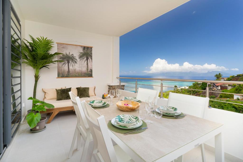 a dining room with a table and chairs and the ocean at Tetavake Luxury Suite in Punaauia