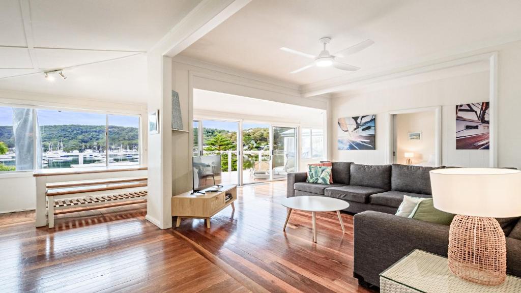 ein Wohnzimmer mit Sofa und Tisch in der Unterkunft 'Classic Cottage on the Bay' by HolidayCo in Hardys Bay