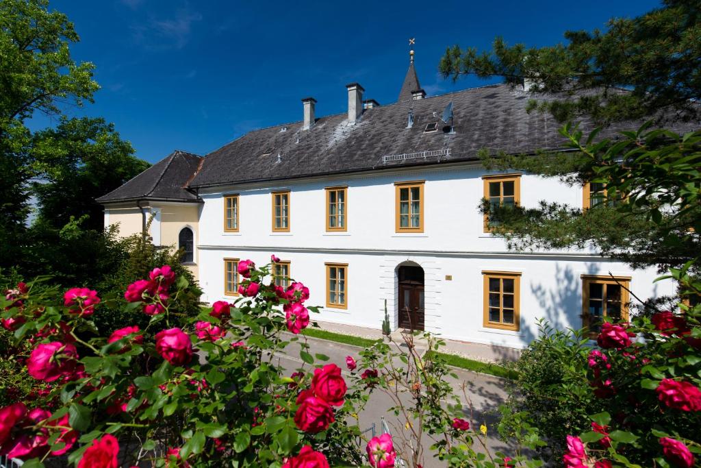 une maison blanche avec des roses rouges devant elle dans l'établissement Himmlisch Urlauben in Tieschen, à Tieschen