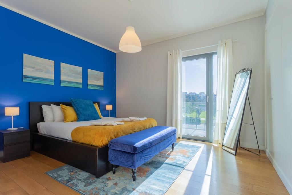 sypialnia z łóżkiem i niebieską ścianą w obiekcie LDapartments - Spacious Lisbon Haven w/Lift&Garage w Lizbonie