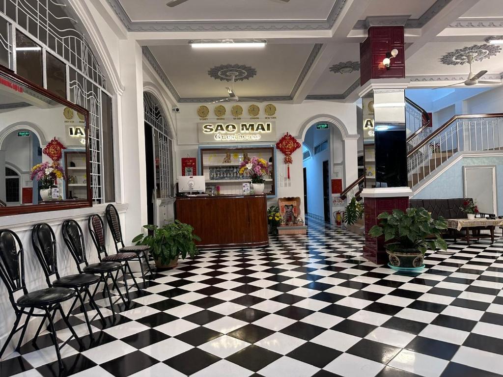 um restaurante com piso em xadrez e cadeiras em Nhà Nghỉ SAO MAI em Hà Tiên