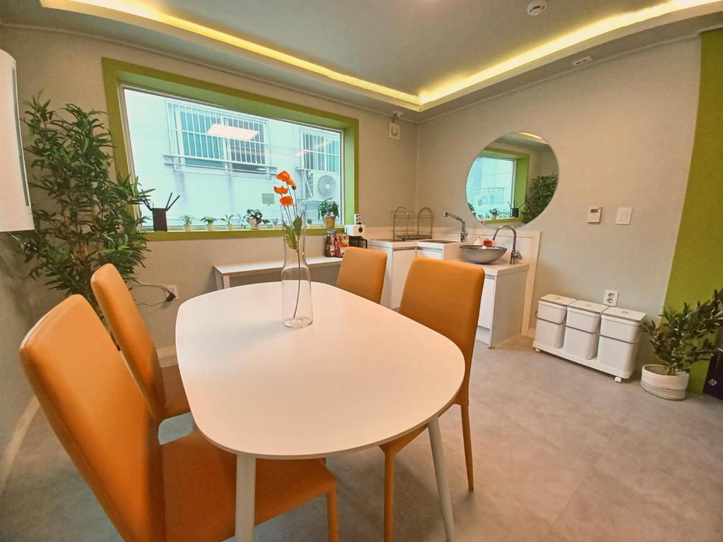 a dining room with a white table and chairs at Four Seasons House (Female only) in Seoul