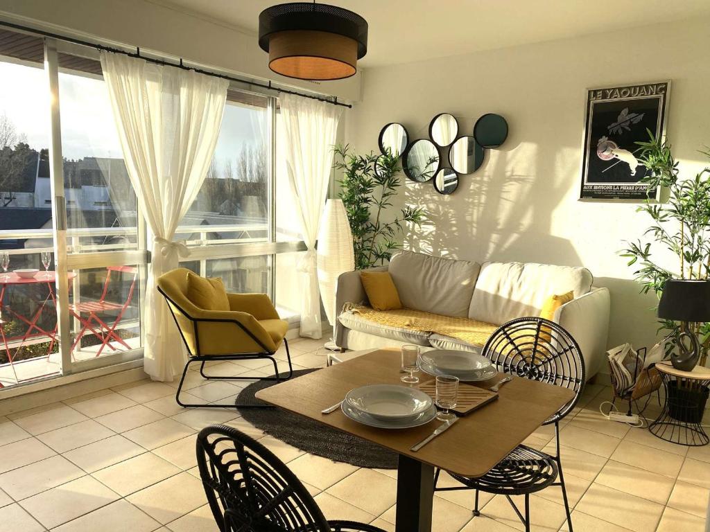 un salon avec un canapé, une table et des chaises dans l'établissement Appartement cosy à Bénodet, 4 pers, plage à 260m, parking privé - FR-1-481-151, à Bénodet