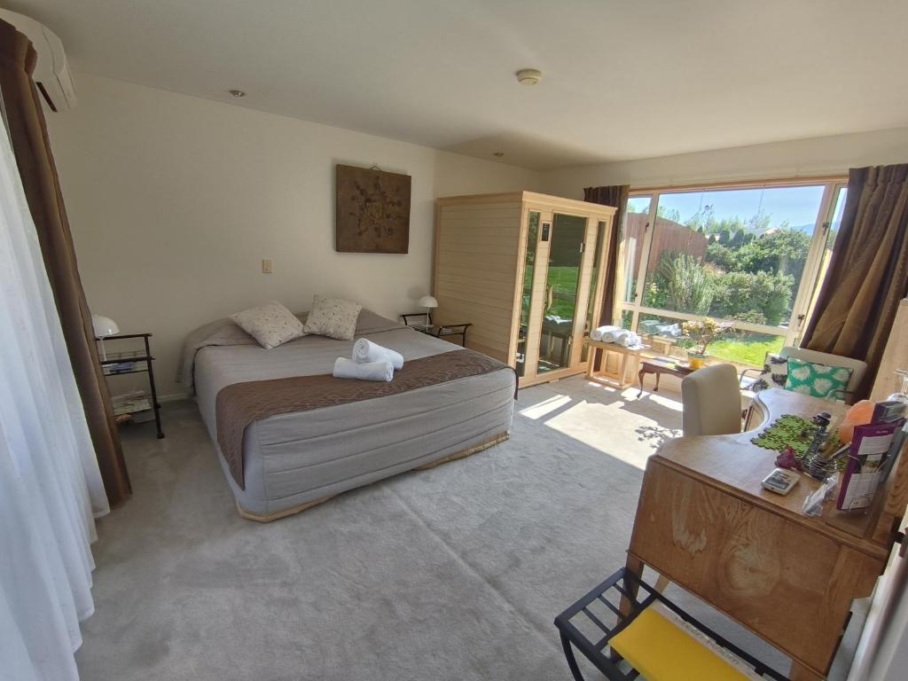 a bedroom with a bed and a living room at Vibrant Living Retreat in Hanmer Springs