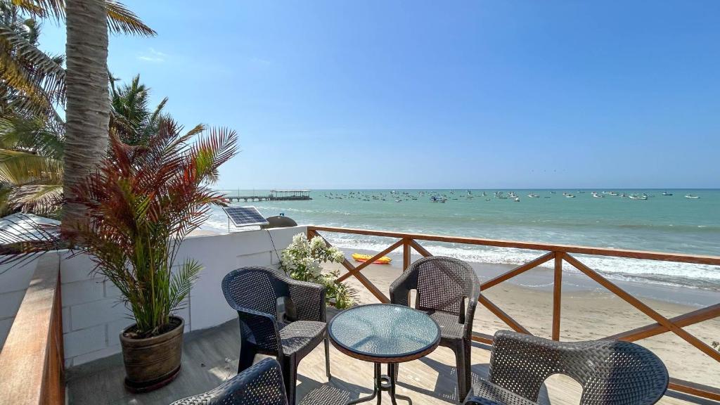 - un balcon avec des chaises, une table et la plage dans l'établissement Marina by Wynwood House, à Máncora