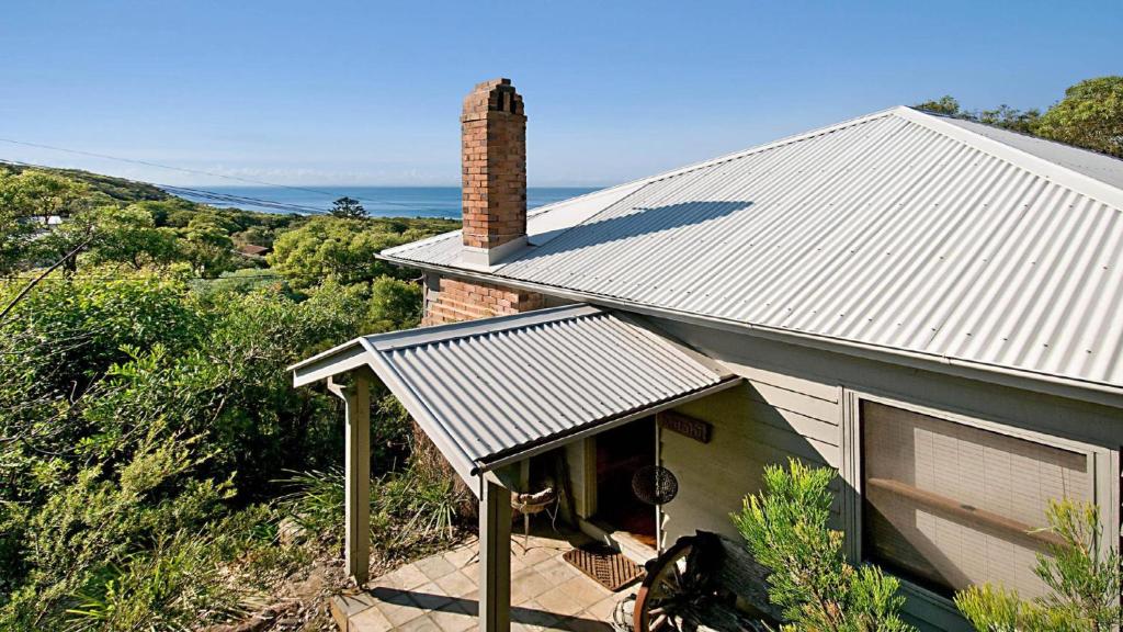 a small house with a window and a roof at 'Charming Cottage Retreat' by HolidayCo in Killcare