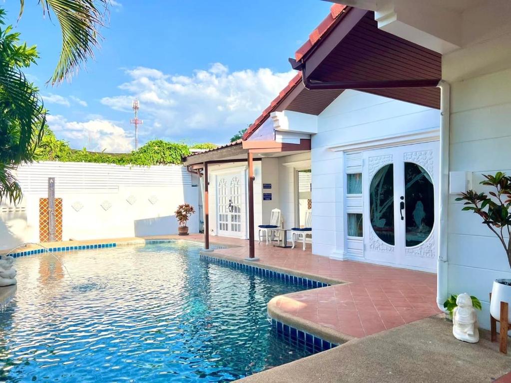 a swimming pool in front of a house at Pattaya Pool Villa39A 300 mater to beach gate exit in Pattaya South