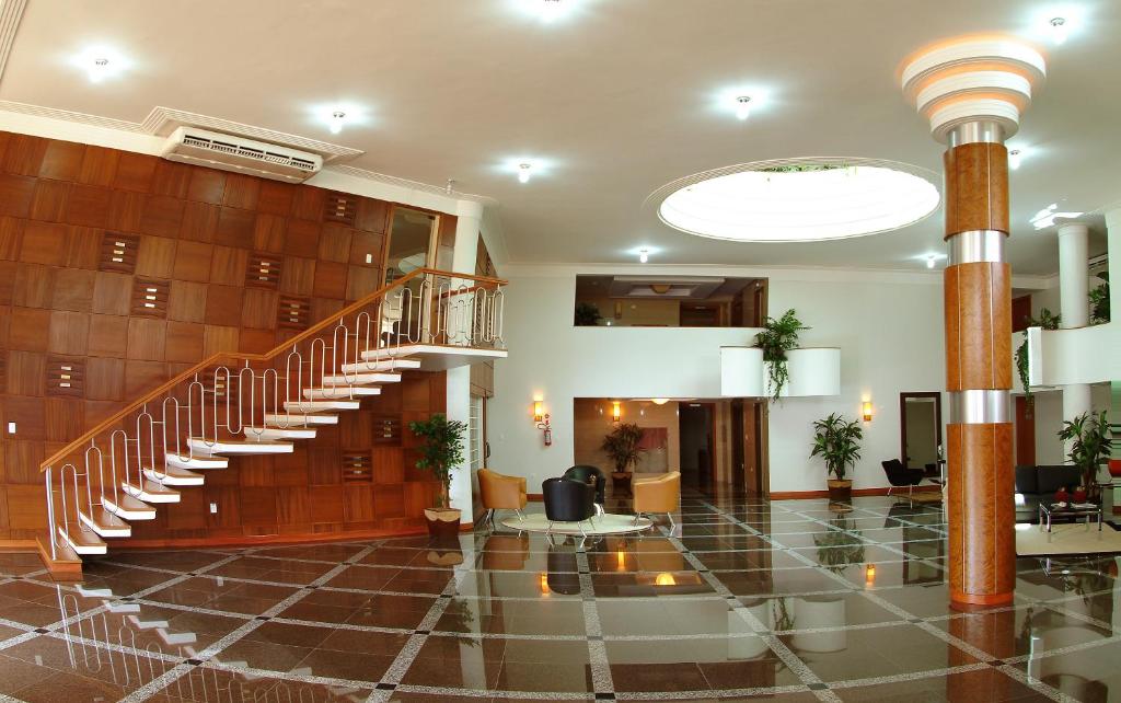 a lobby with a spiral staircase in a building at Copas Executive Hotel in Cascavel