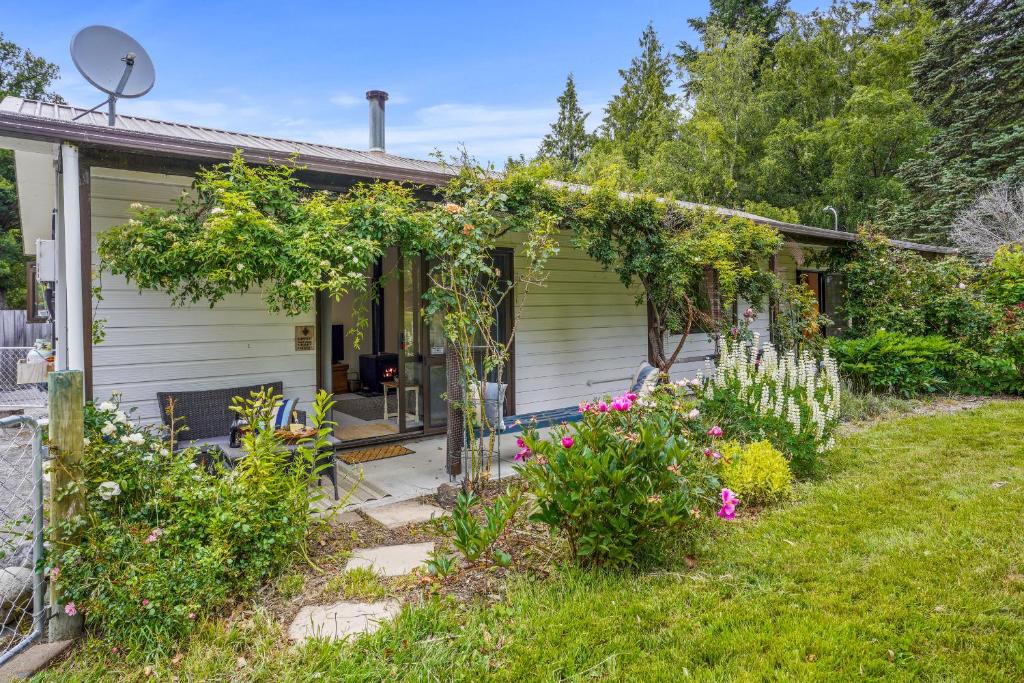 una pequeña casa con un jardín frente a ella en Rose Cottage - Lake Coleridge Holiday Home, en Lake Coleridge