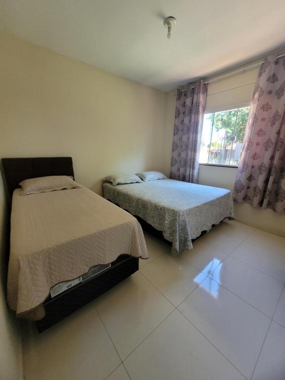 1 dormitorio con 2 camas y ventana en Casa para aluguel de diárias, en Foz do Iguaçu