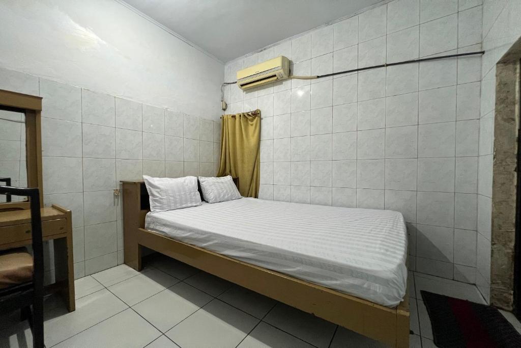 a small bedroom with a bed in a room at OYO 93429 Pondok Surya in Pakato