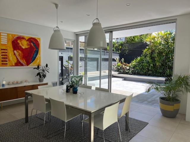 uma sala de jantar com mesa e cadeiras numa casa em Modern Queens Park Home near Bondi Junction, Bondi Beach & City em Sydney