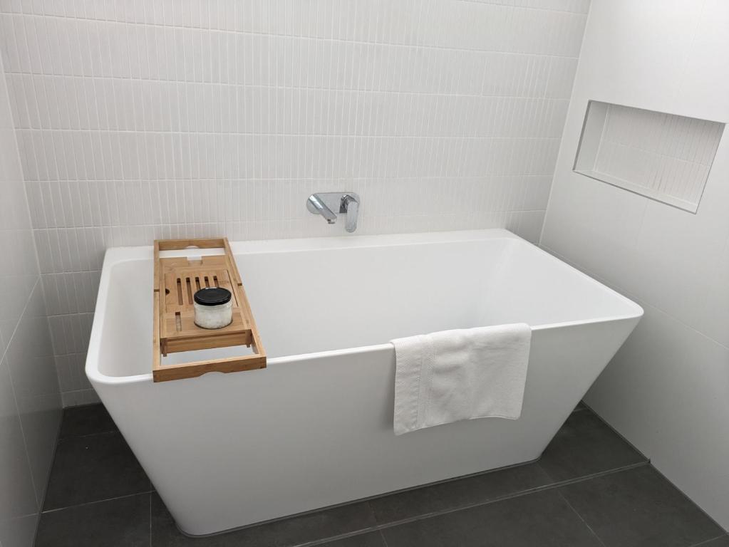 a white bath tub in a bathroom with a sink at 2 bedroom apartment with Garden views in Sydney in Sydney