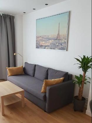 un salon avec un canapé bleu dans une pièce dans l'établissement Chez vous au coeur de Paris Convention - Vaugirard, à Paris