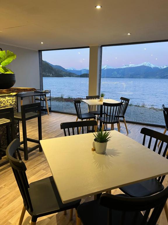 a table and chairs with a view of the water at Chelenko Lodge in Puerto Tranquilo