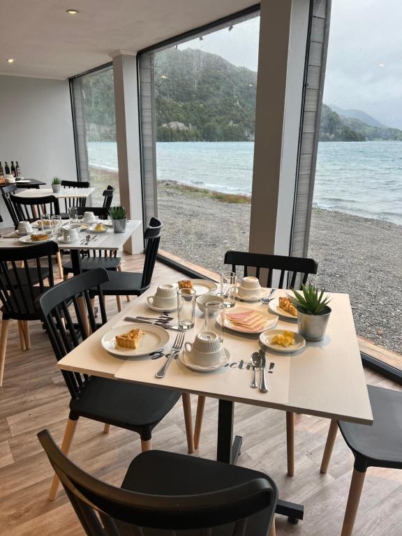 a dining room with a table with plates of food at Chelenko Lodge in Puerto Tranquilo