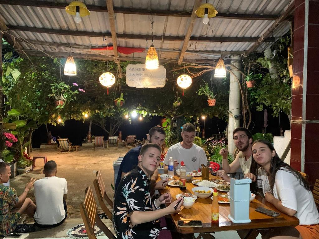 een groep mensen die rond een tafel in een restaurant zitten bij Hai Long homestay in Hội An