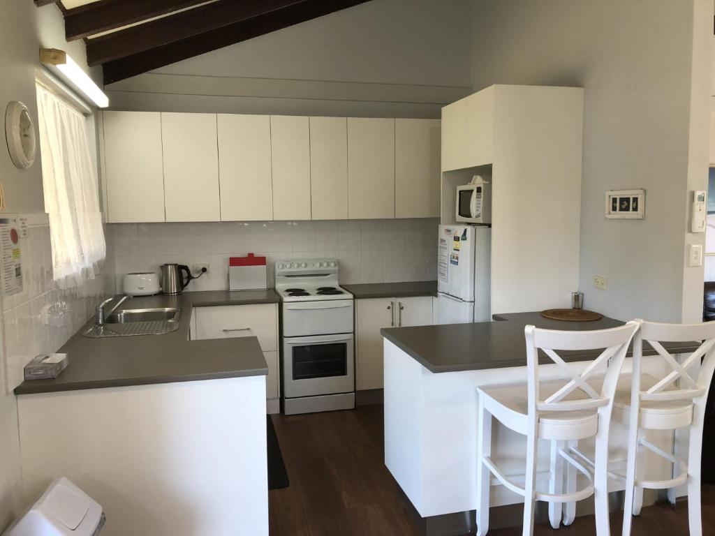 a kitchen with white cabinets and white appliances at Stouty's at Hat Head - No Sheets or Towels Provided in Hat Head