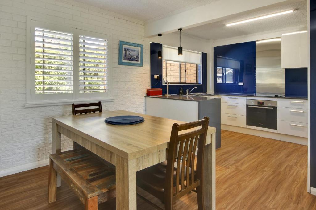 a kitchen with a wooden table and chairs in a room at Azure Beach Stop in South West Rocks