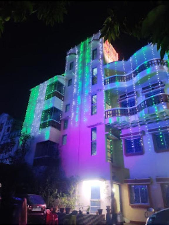 um edifício é iluminado em verde e roxo em Roxy Inn,Cuttack em Cuttack