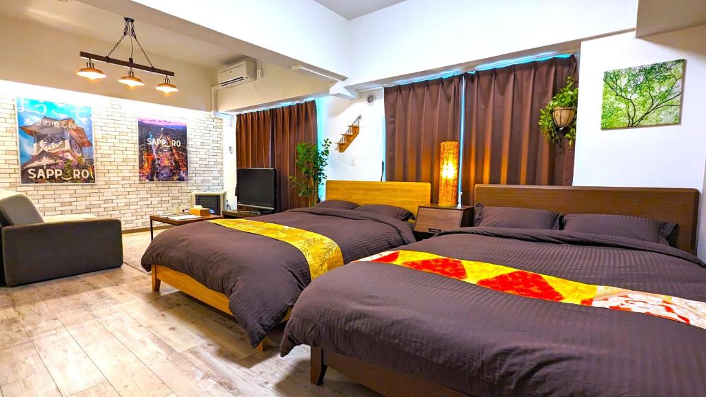 a bedroom with two beds and a television in it at KIYAZA Station Sapporo 2 in Sapporo