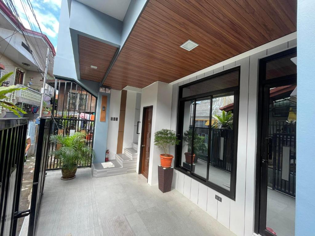 un bâtiment avec une terrasse couverte agrémentée de plantes en pot dans l'établissement SHOWMECAS Alley Stay, à Tagbilaran