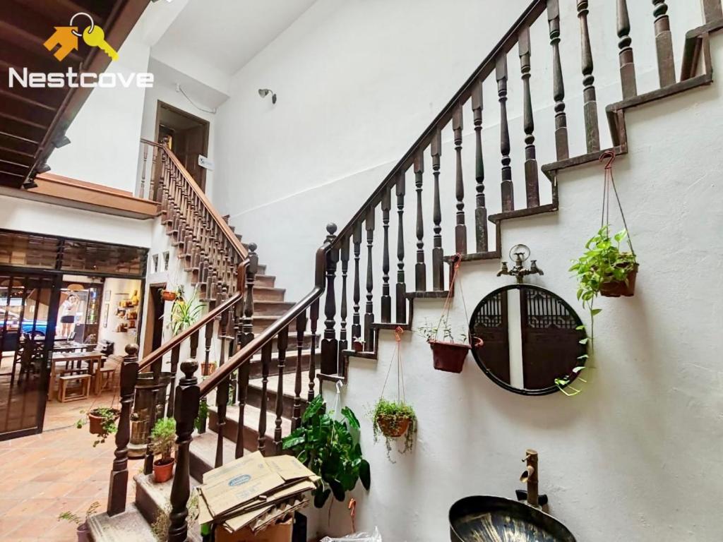 a hallway with a staircase with potted plants at SOINN Jonker Guesthouse By Nestcove in Malacca