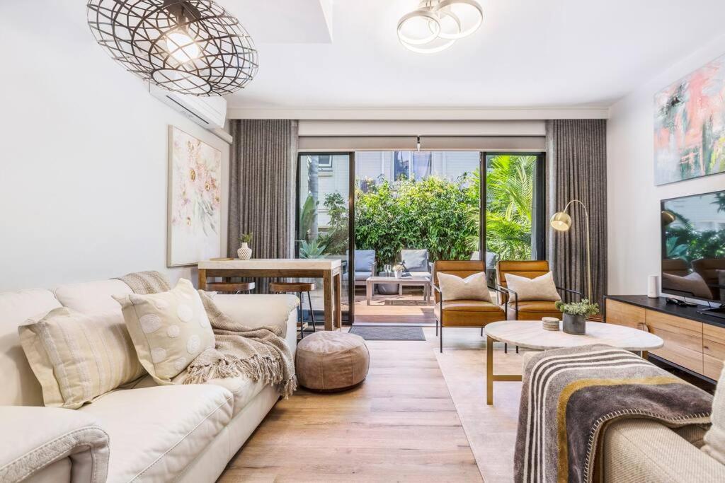 - un salon avec un canapé et une table dans l'établissement Urban Green - Stylish Courtyard Haven off Malvern Rd, à Melbourne