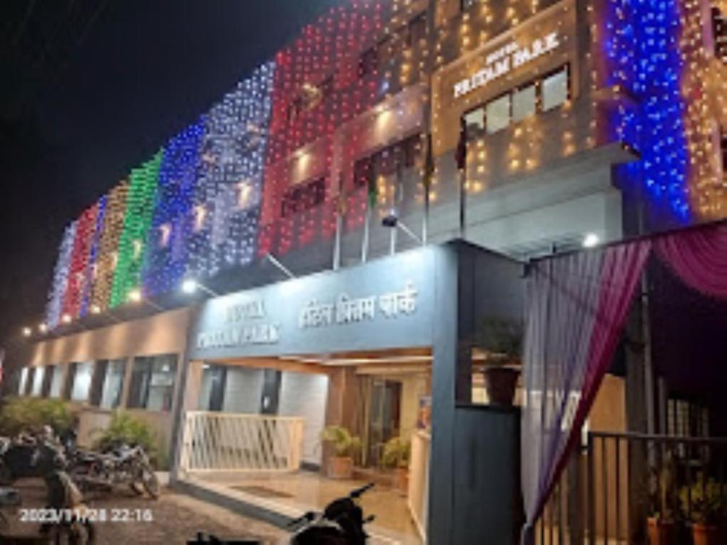 ein Gebäude mit farbenfroher Beleuchtung an der Seite in der Unterkunft HOTEL PRITAM PARK, Jalgaon, Maharashtra in Jālgaon