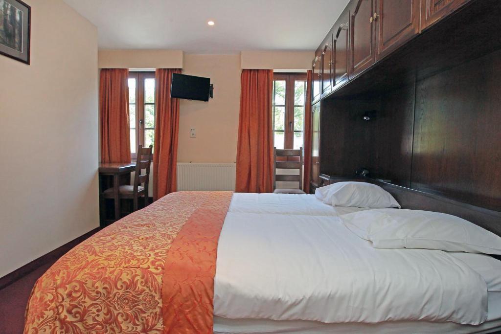 Postel nebo postele na pokoji v ubytování Logis Hôtel Le Menobu