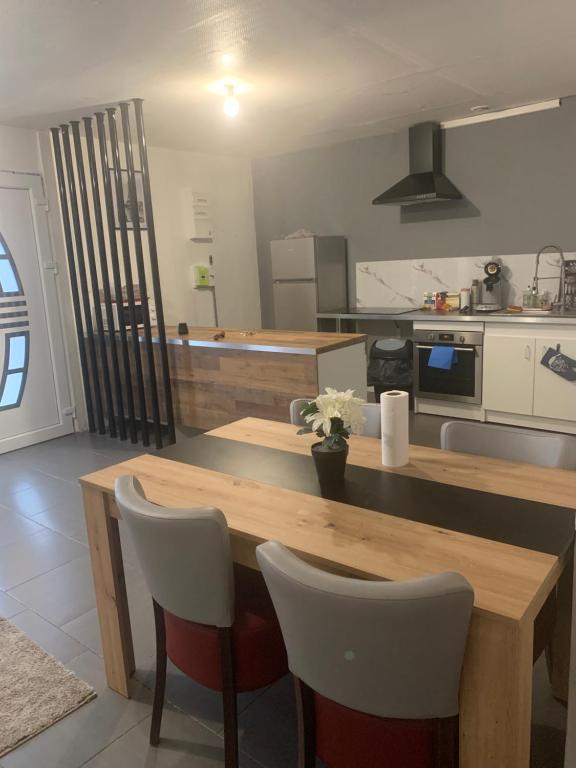 a kitchen with a wooden table and two chairs at Maison entière proche circuit des 24 heures in Le Mans