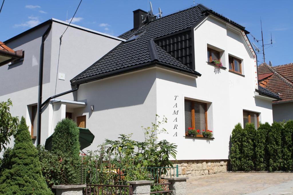 una casa blanca con techo negro en Dům Tamara, en Luhačovice