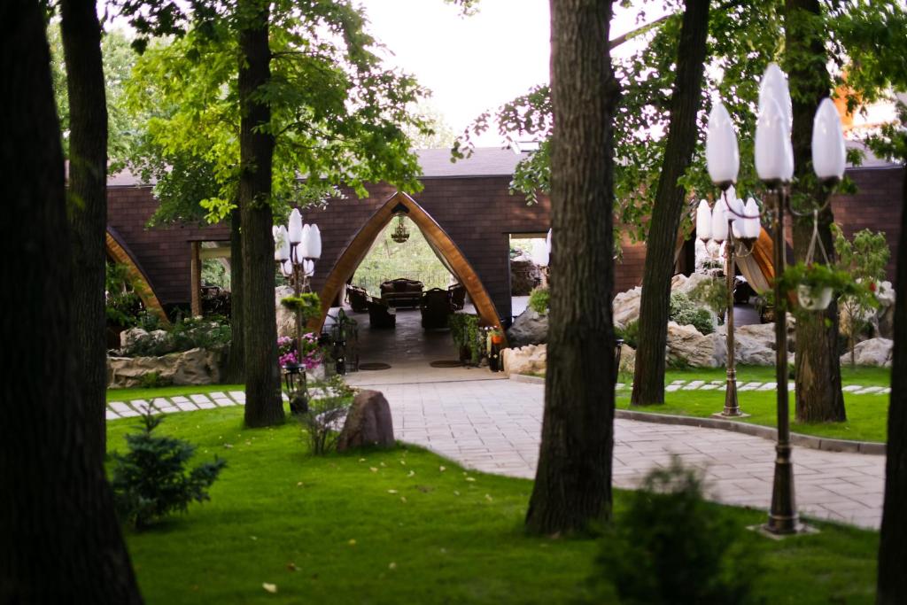 einen Torbogen in einem Garten mit Bäumen in der Unterkunft Hotel Restaurant La Castel in Iaşi