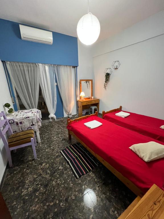 a bedroom with a red bed and a table at Past or Tail rooms in Larnaka