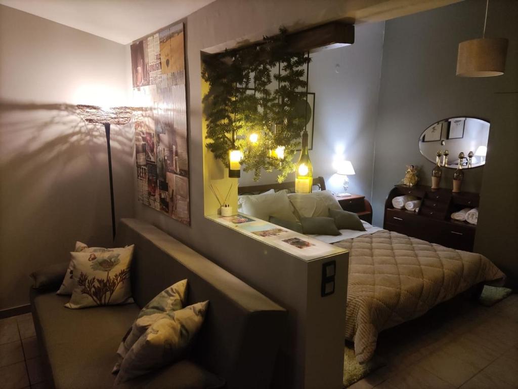 1 dormitorio con cama, mesa y sofá en Wine Reflections Apartment near Nafplio, en Nea Kios