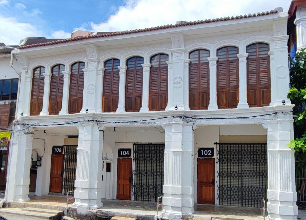 a white building with brown doors and windows at TREASURE HUNTER At Heritage Georgetown in George Town